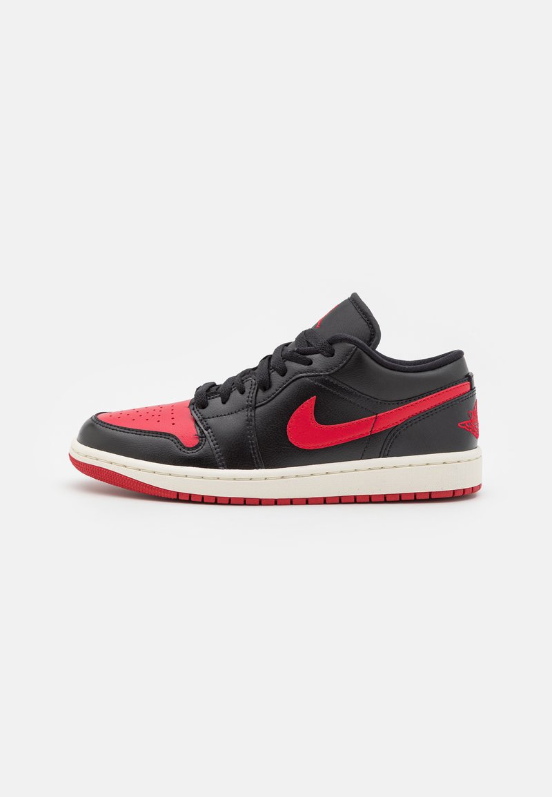 Sneaker in pelle nera con accenti rossi, dotato di una tomaia perforata, collo imbottito e suola intermedia bianca con suola in gomma rossa.