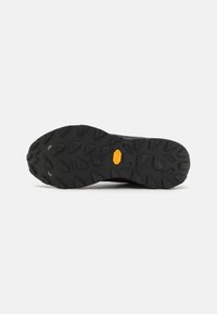 Semelle extérieure en caoutchouc noir avec des crampons multidirectionnels et un logo Vibram, conçue pour la durabilité et l'adhérence sur divers terrains.