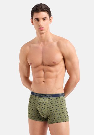 Boxer shorts verde con motivo, con una cintura blu navy che presenta il logo "Emporio Armani". Il tessuto ha una texture morbida e un design aderente.