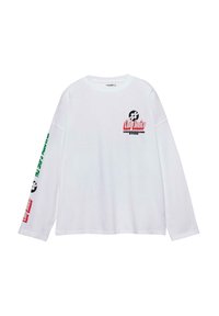 T-shirt blanc à manches longues avec imprimés graphiques en noir, rouge et vert. Coupe décontractée avec un col rond et des poignets côtelés.