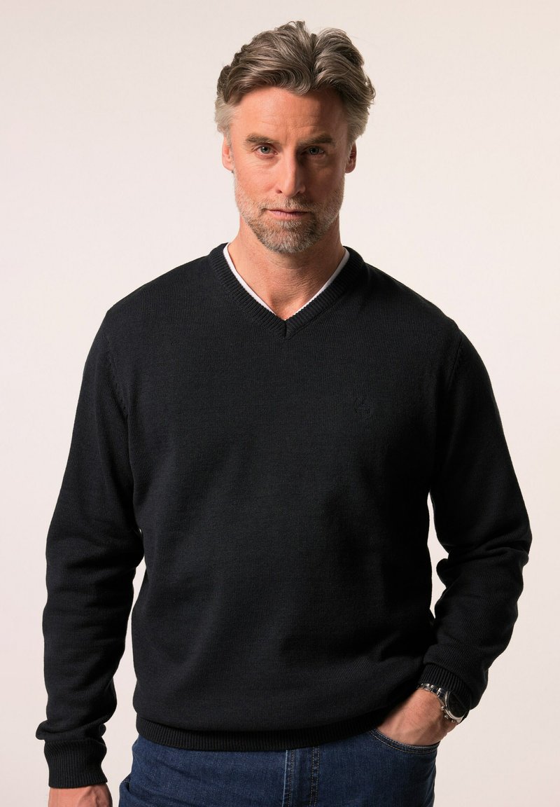 Schwarzer gestrickter Pullover mit V-Ausschnitt, gerippten Bündchen und Saum. Verfügt über ein dezentes Logo in der Nähe der Brust und einen kontrastierenden inneren Kragen.