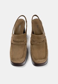 Pantofi slingback din suede maro, cu vârf pătrat și insole căptușit. Au o curea decorativă și o talpă contrastantă, asemănătoare cu lemnul.