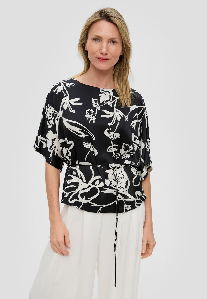Zwarte bloemenblouse met korte mouwen, voorzien van een witte botanische print en een koord in de taille voor een verstelbare pasvorm; gladde, lichte stof.