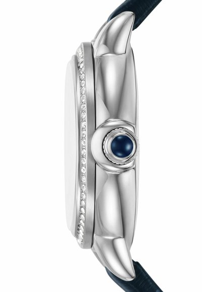 Perfil de un reloj de metal plateado que presenta una caja lisa, una corona circular azul y un bisel adornado con diamantes. Se puede ver el attachment de una correa de cuero oscuro.
