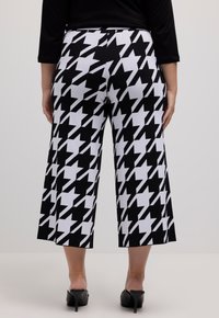 Zwart-witte houndstooth-patroon wijdvallende cropped broek, gemaakt van rekbare stof, met een gladde textuur en een hoge tailleband.