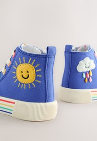 Sneakers alte blu con ricami di sole e nuvole, dotate di suola in gomma con strisce multicolore e superficie in tela testurizzata.