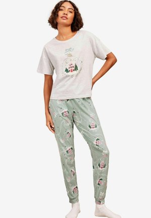 Hallitusvärvi lühikeste varrukatega ööpluus, millel on pühade kaunistuse graafika. Rohelised püksid, millel on pidulikud maja ja puu mustrid, elastne vöökoht, pehme kangas.