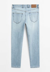 Light blue denim jeans with a straight leg design, featuring five pockets, a leather label at the back waistband, and visible stitching details.