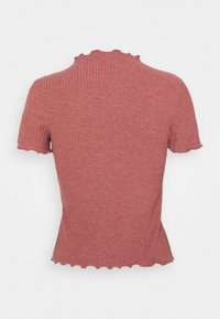 Haut à manches courtes en rose doux, avec un col et un ourlet volantés. Fabriqué en tissu doux et texturé.