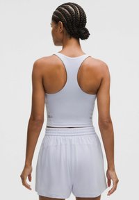 Ljuslila sportig crop top med racerback-design, i kombination med matchande högmidjade shorts med elastisk midja.
