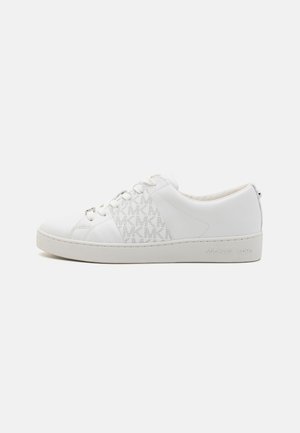 White sneaker made of leather with a rubber sole, featuring a side panel of MK logo pattern, flat laces, and embossed brand name on heel.