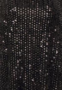 Černá flitrová látka s vertikálními liniemi a lesklými kulatými flitry, která nabízí texturovaný, reflexní povrch s hladkým pozadím.