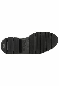 Semelle de chaussure en caoutchouc noir avec rainures horizontales, logo en relief et surface texturée pour l'adhérence. Présente un bout arrondi et un design sectionné.