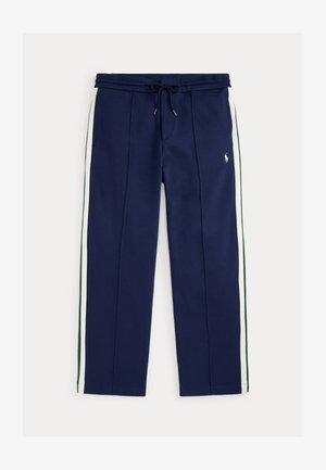 Marineblauwe joggerbroek met witte en groene zijstrepen, trekkoord in de taille, voorzakken en klein wit geborduurd logo op de rechterdij.