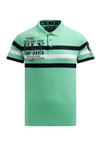 Green polo shirt featuring horizontal navy and white stripes, 3-button placket, and printed text with aviation-themed graphics.