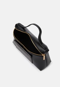 Fekete szintetikus bőr kézitáska arany cipzárral, téglalap alakú, felső fogantyúval és texturált fekete geometrikus mintával az elején.