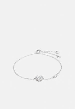 Bracciale in argento con ciondolo a forma di cuore arricchito da accenti trasparenti e scintillanti. Chiusura regolabile con piccolo dettaglio circolare in metallo.