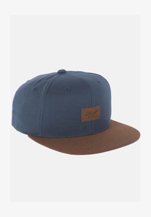 Blaue Stoffmütze mit einem braunen Wildleder-Visier; versehen mit einem rechteckigen braunen Lederetikett auf der Vorderseite. Die Form ist im klassischen Snapback-Stil.