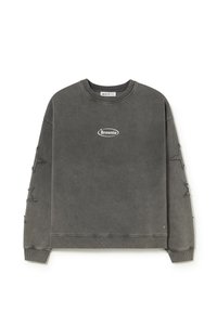 Sudadera gris oscuro con cuello redondo, con el logo "Brownie" en el pecho y parches de estrellas desgastadas en ambas mangas.