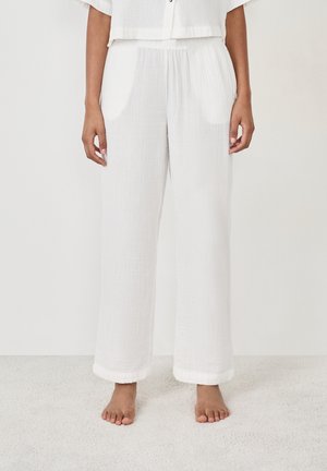 White, loose-fitting pants made of lightweight fabric with a crinkled texture. Features an elastic waistband and rolled hems.