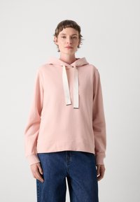 Felpa rosa chiaro realizzata in tessuto morbido, con tasca frontale, cappuccio con cordoncino a contrasto crema e polsini a coste.