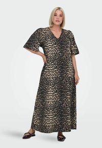 Maksi haljina s uzorkom leoparda, v-izrezom i kratkim, širokim rukavima. Izrađena od laganog materijala, s opuštenim krojem i lepršavim dizajnom.