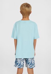 Šviesiai mėlyna medvilninė marškinėliai trumpomis rankovėmis, derinami su baltais ir mėlynais lapų raštuotais šortais. Paprastas dizainas, patogus kirpimas.