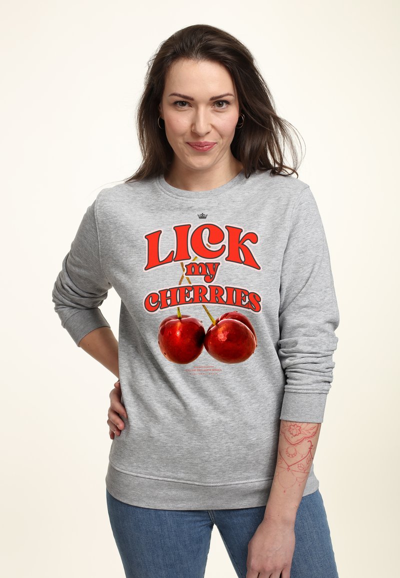 Felpa grigia con scritta in rosso brillante "LICK my CHERRIES" e due grafiche di ciliegie rosse lucide. Maniche lunghe e polsini a coste.