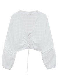 Blouse blanche courte avec un décolleté en V profond, détail de laçage à l'avant et manches larges. Fabriquée en tissu léger avec un subtil motif carreauté et des accents en dentelle.