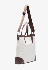 Canvas tote bag with brown leather accents, featuring dual top handles and an adjustable shoulder strap. Color: white and brown.