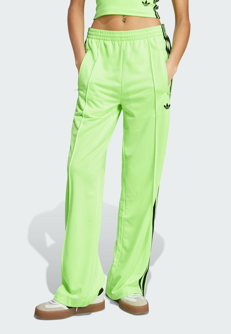 Neon groene trainingsbroek met zwarte zijstrepen, elastische tailleband en zijzakken. Gladde textuur en losse pasvorm, ontworpen voor comfort.