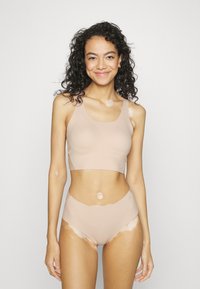 Nahaõlane ühtne sportbra ja kõrge vöökohaga aluspüksid pehmest ja venivast materjalist, millel on sile viimistlus ja minimalistlik disain.