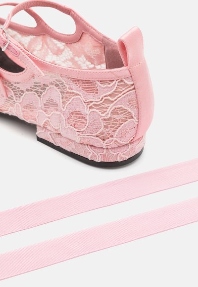 Zapato rosa de encaje con un patrón floral texturizado y acentos rosas lisos. Incluye tiras de cinta rosa a juego y suela plana negra.