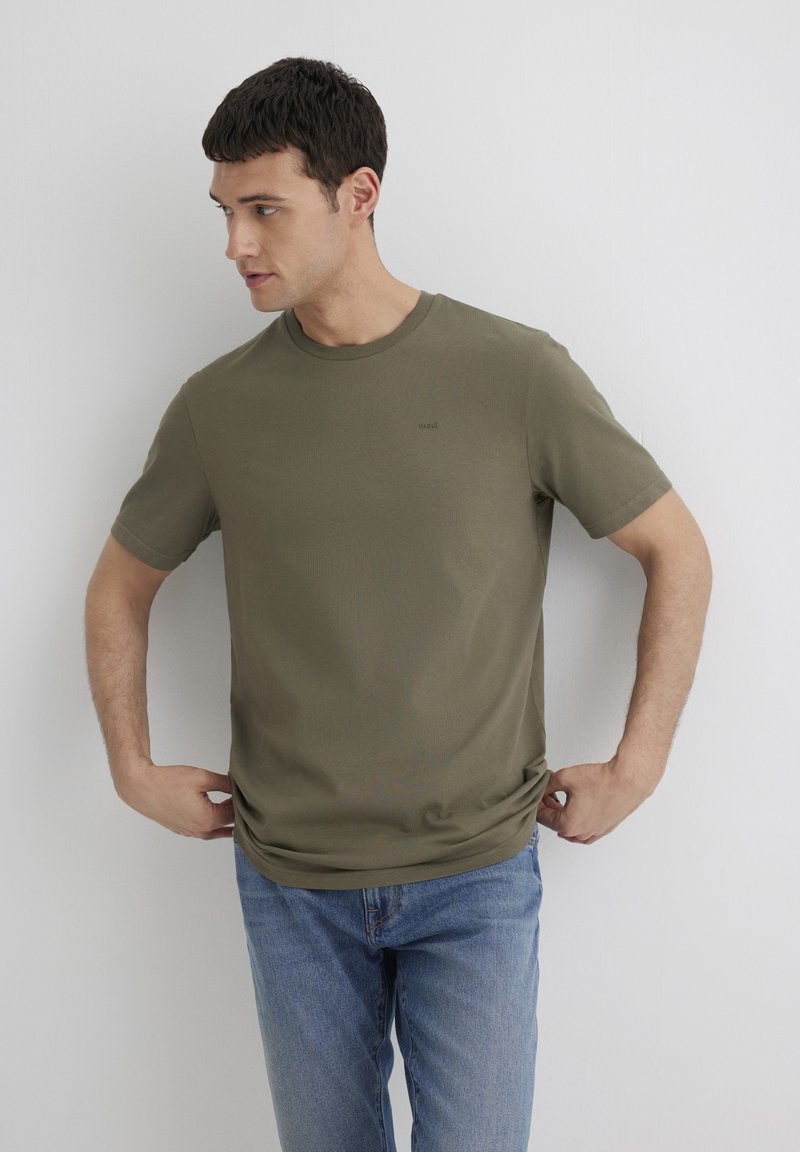 Olivgrünes T-Shirt mit kurzen Ärmeln aus glattem Stoff, mit Rundhalsausschnitt und minimalem Logo oberhalb der linken Brust.