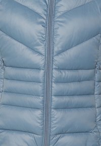Niebieska kurtka puchowa z pikowanym wzorem, z poziomym i zygzakowatym przeszyciem, centralnym zamkiem błyskawicznym oraz błyszczącym materiałem zewnętrznym.