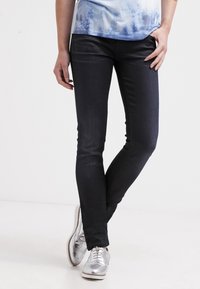 Mörka denim skinny jeans med en slät yta, som har en klassisk femficksdesign och minimal blekning. Parat med metalliska silver skor.