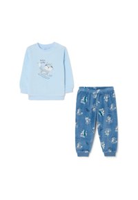 Haut à manches longues bleu clair avec un graphisme de chat en train de skier, associé à un pantalon bleu décoré d'imprimés d'animaux de ski. Tissu doux.