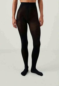 Mustad mustad retuusid kõrge vöökoha, sileda tekstuuri ja täies ulatuses katvusega, ulatudes vöökohtadest kuni pahkluudeni.