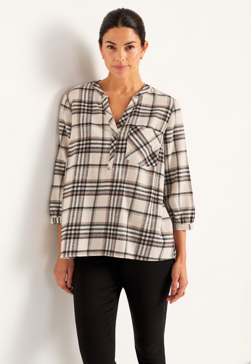 Geruite shirt in beige, zwart en bruine tinten. Heeft een V-hals, lange mouwen en een voorzak. Gemaakt van zacht, gestructureerd stof.