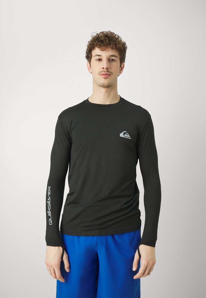 Juodas ilgomis rankovėmis sportinis marškinėliai su prigludusia forma, su mažo pilko logotipo ant krūtinės ir sidabriniu 28;Quiksilver29; ant rankovės.