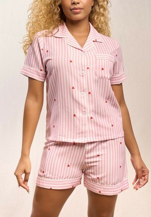 Ensemble de pyjama rayé rose et blanc avec des accents de cœur rouge ; haut boutonné à manches courtes et short assorti avec ourlets retournés.