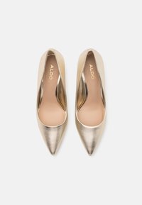 Paire d'escarpins métalliques dorés pour femmes, à bout pointu, de la marque Aldo, vus de dessus sur un fond blanc.