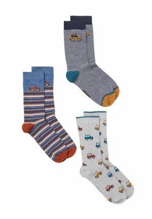 Drei Paare bunte Socken mit kleinen Autodesigns, eines gestreift blau und orange, eines marineblau mit dünnen Streifen und eines grau mit mehrfarbigen Autos.