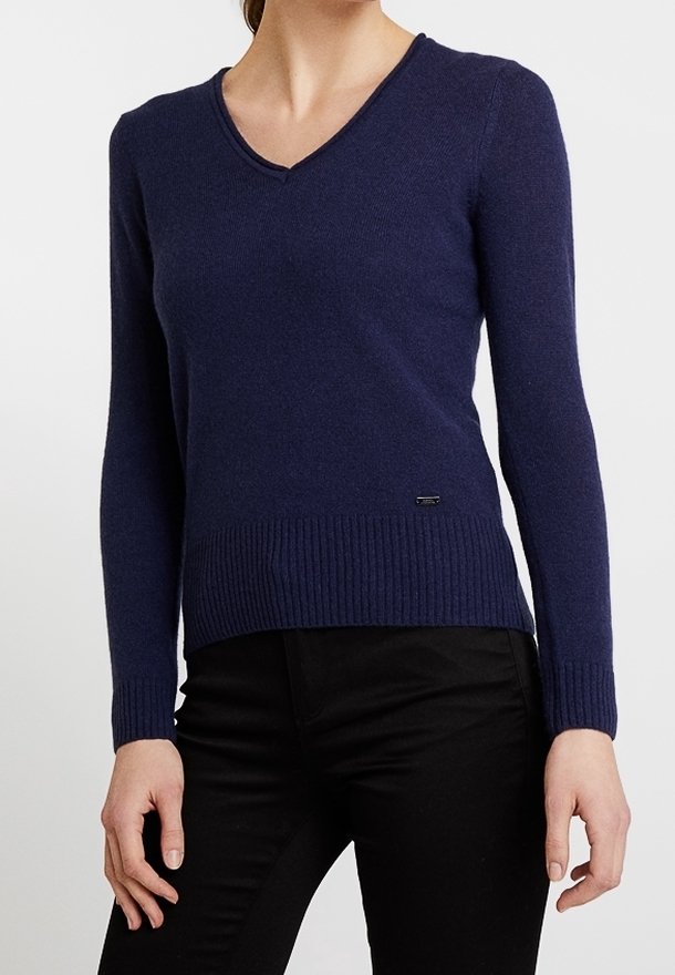 Maglione blu navy lavorato a maglia con scollo a V, orlo a coste e maniche lunghe, realizzato in materiale morbido. Presenta un piccolo dettaglio con logo vicino all'orlo.