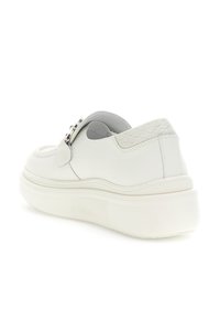 Sneaker bianco in pelle con retro testurizzato, forma allungata e suola in gomma. Presenta una fibbia decorativa in argento sulla parte superiore.
