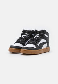 Czarno-białe sneakersy wysokie z teksturowanej skóry, gumową podeszwą i czarnymi sznurowadłami. Posiadają perforowane detale na palcach.