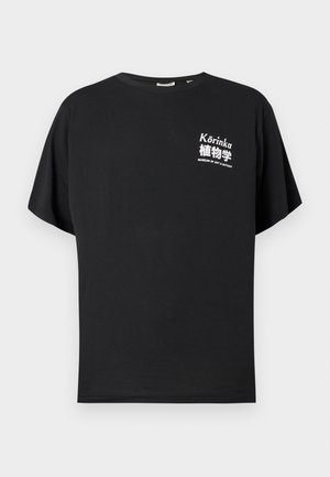 Musta puuvillapaita, jossa on pyöreä pääntie ja lyhyet hihat. Edessä on valkoista tekstiä, mukaan lukien "Kórinka" ja "TAITEEN JA BOTANIIKAN MUSEO."