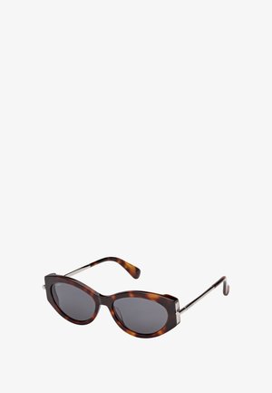 Schildpad kat-oog zonnebril met donkere getinte lenzen en dunne metalen armen op een witte achtergrond.