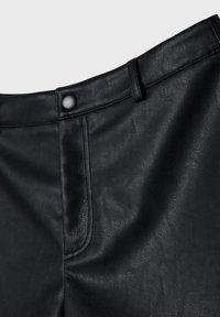 Zwarte leren broek met een gestructureerde afwerking, voorzien van een sluitknop aan de voorkant, riemlussen en minimalistische stikseldetails.