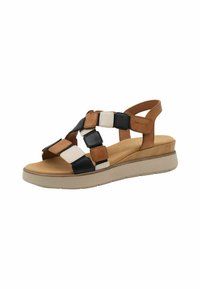 Bruine, zwarte en witte leren sandalen met een blokontwerp, voorzien van een verstelbare enkelband en een lichtgekleurde wigzool.